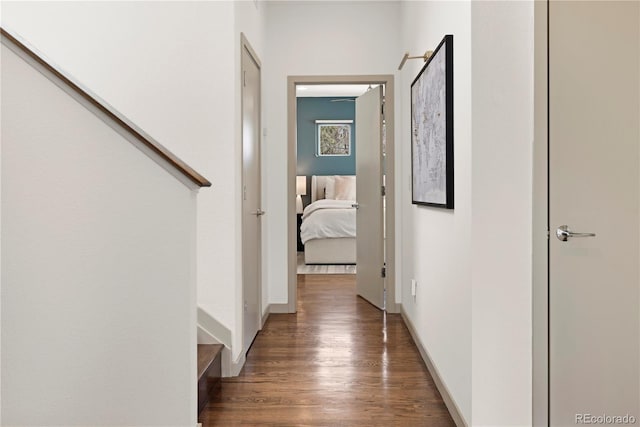corridor featuring baseboards and wood finished floors