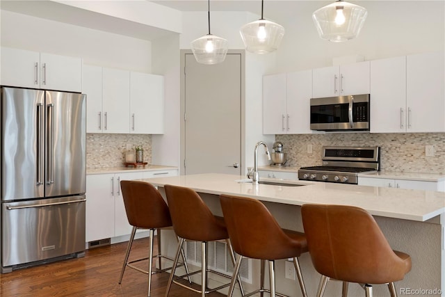 4035 Fenton Ct, Wheat Ridge, CO 80212 - kitchen with stainless steel appliances, a sink, decorative backsplash, light countertops, and dark wood-style floors