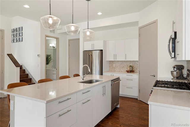 4035 Fenton Ct, Wheat Ridge, CO 80212 - kitchen featuring stainless steel appliances, a sink, backsplash, dark wood-style flooring, and white cabinets