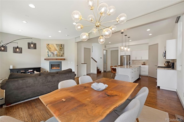 4035 Fenton Ct, Wheat Ridge, CO 80212 - dining room featuring recessed lighting, a warm lit fireplace, stairs, dark wood-style flooring, and a chandelier