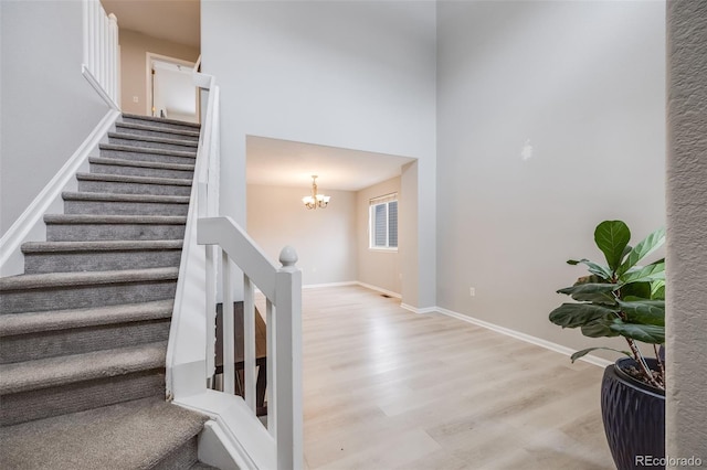 4821 N Silverlace Dr, Castle Rock, CO 80109 - staircase with baseboards, a high ceiling, wood finished floors, and a notable chandelier