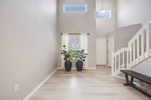 4821 N Silverlace Dr, Castle Rock, CO 80109 - entryway featuring stairway, baseboards, a high ceiling, and light wood-style flooring