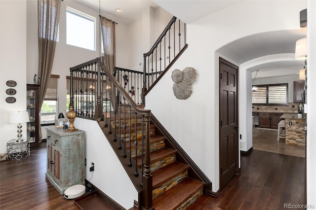 3791 Charterwood Cir, Highlands Ranch, CO 80126 - staircase featuring wood finished floors and arched walkways