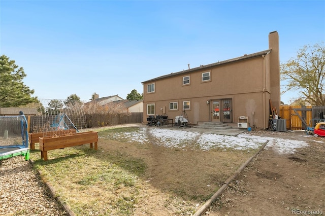 rear view of house featuring french doors, a trampoline, a patio area, and central air condition unit