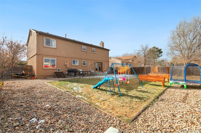 back of house with a playground, a patio area, and a trampoline