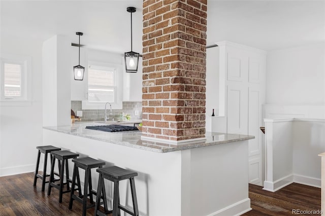 4828 W 32nd Ave, Denver, CO 80212 - kitchen featuring a breakfast bar area, decorative backsplash, dark wood-style flooring, and light stone countertops