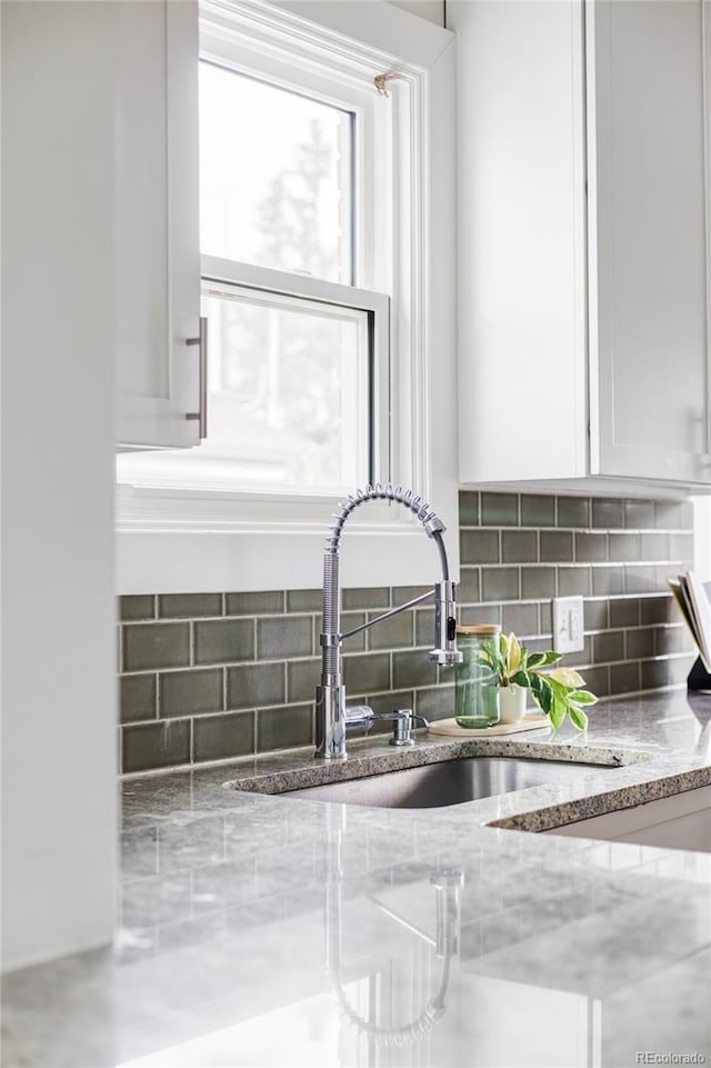 4828 W 32nd Ave, Denver, CO 80212 - room details with a sink, light stone countertops, decorative backsplash, and white cabinets