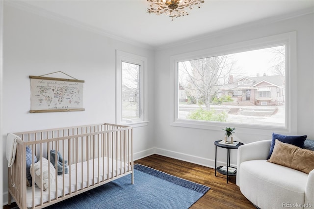 4828 W 32nd Ave, Denver, CO 80212 - bedroom with baseboards, crown molding, a crib, and wood finished floors