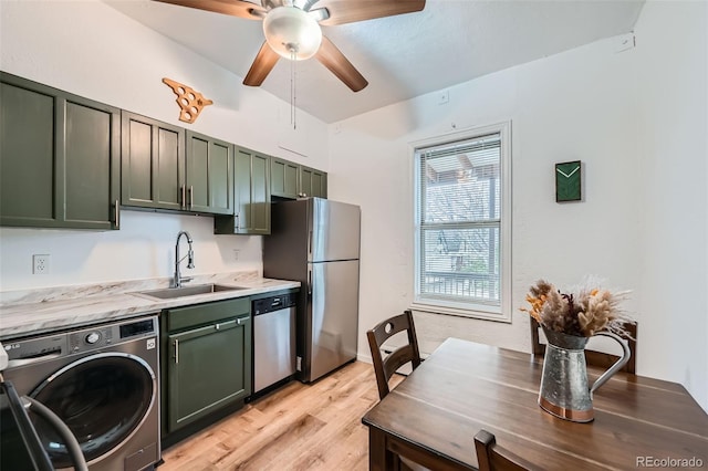 3127 W 28th Ave Unit 2, Denver, CO 80211 - kitchen with green cabinetry, a sink, light wood finished floors, stainless steel appliances, and washer / dryer