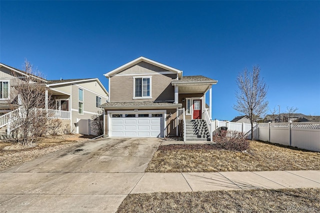 5534 Killarney St, Denver, CO 80249 - tri-level home featuring a porch, stairway, fence, concrete driveway, and an attached garage