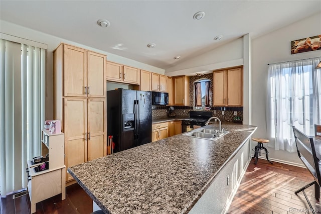 5534 Killarney St, Denver, CO 80249 - kitchen with lofted ceiling, light brown cabinetry, tasteful backsplash, a sink, and black appliances