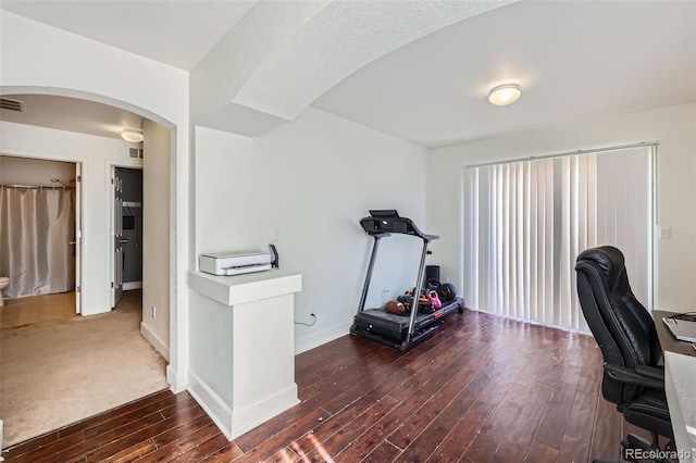 5534 Killarney St, Denver, CO 80249 - office area with arched walkways, baseboards, visible vents, and hardwood / wood-style floors