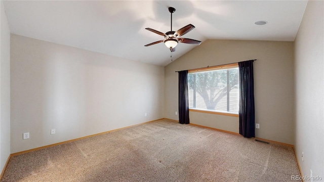 spare room featuring lofted ceiling, light colored carpet, visible vents, ceiling fan, and baseboards