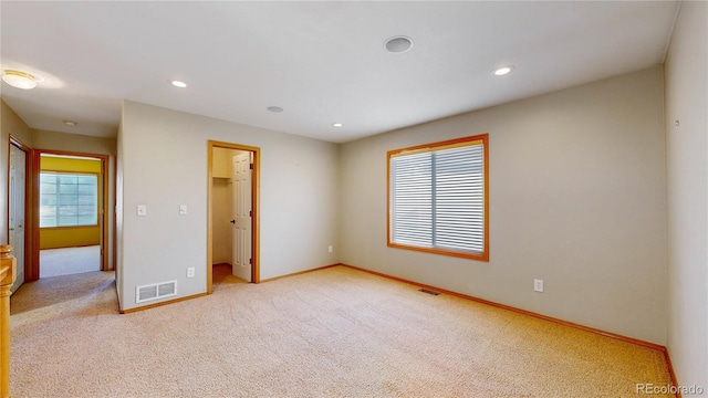 spare room featuring a wealth of natural light, baseboards, visible vents, and carpet flooring