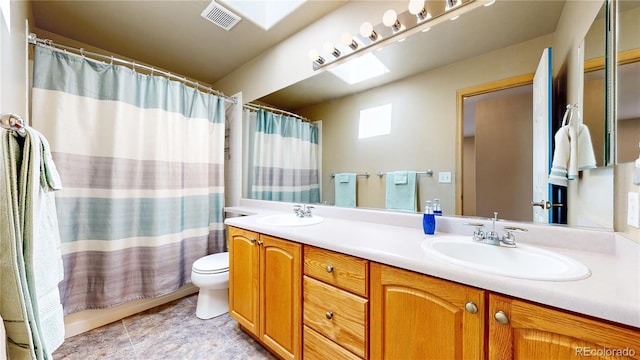 full bathroom with a skylight, visible vents, a sink, and double vanity