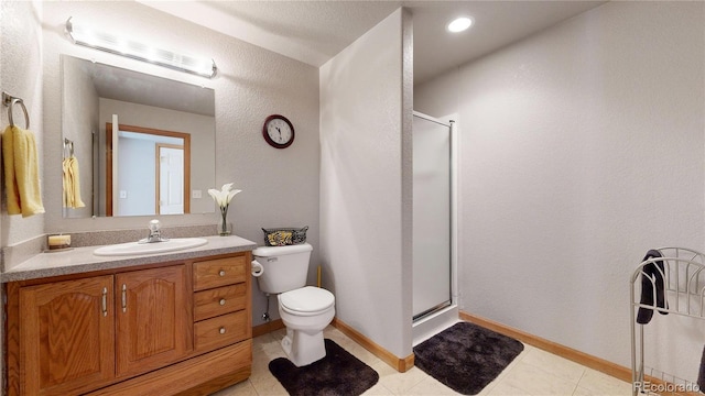 full bathroom with a stall shower, vanity, toilet, and baseboards