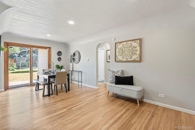 dining space featuring a textured ceiling and light hardwood / wood-style floors