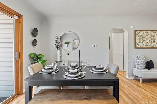 dining space with wood-type flooring