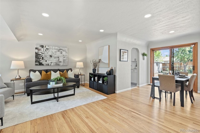 living room with a textured ceiling and light hardwood / wood-style flooring