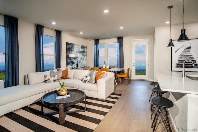 living area featuring recessed lighting, plenty of natural light, and wood finished floors