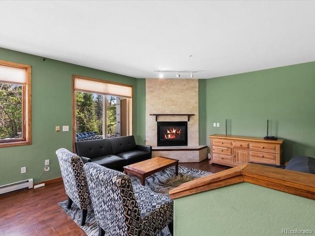 10000 Ryan Gulch Rd Unit 116, Silverthorne, CO 80498 - living area with wood finished floors, a large fireplace, track lighting, and a baseboard radiator