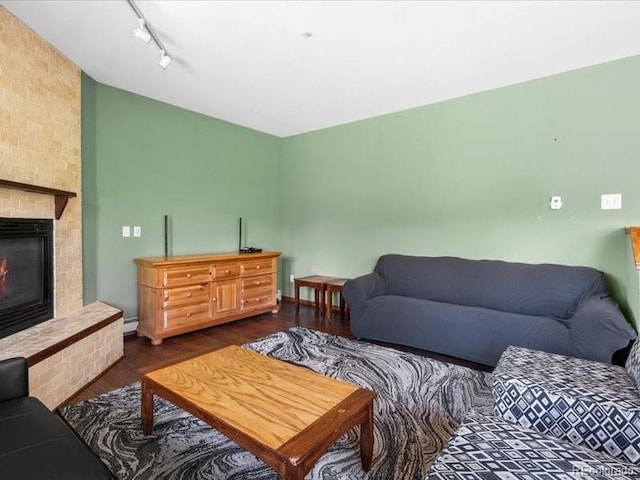 10000 Ryan Gulch Rd Unit 116, Silverthorne, CO 80498 - living area featuring dark wood-type flooring, rail lighting, a brick fireplace, and baseboard heating