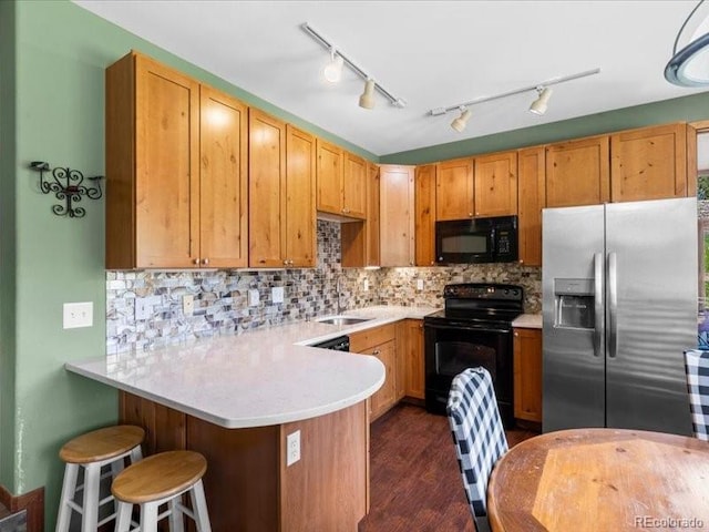 10000 Ryan Gulch Rd Unit 116, Silverthorne, CO 80498 - kitchen with black appliances, a peninsula, light countertops, and tasteful backsplash