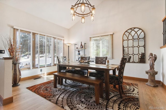 dining room with lofted ceiling, light hardwood / wood-style flooring, and plenty of natural light