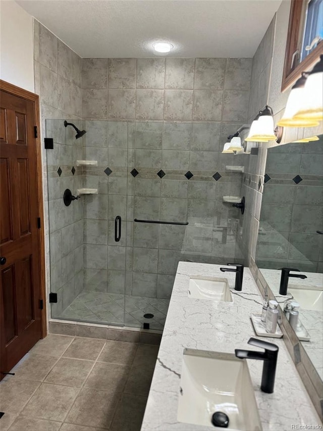 bathroom with walk in shower, vanity, and tile patterned floors