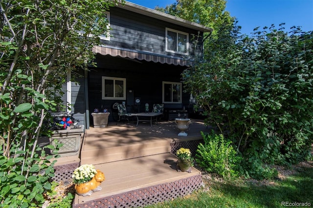 rear view of property featuring a wooden deck