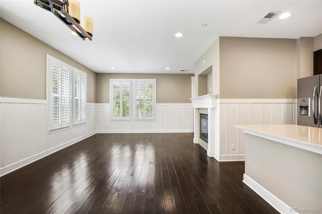 3450 Valentia St, Denver, CO 80238 - unfurnished living room featuring wainscoting, dark wood finished floors, and a glass covered fireplace