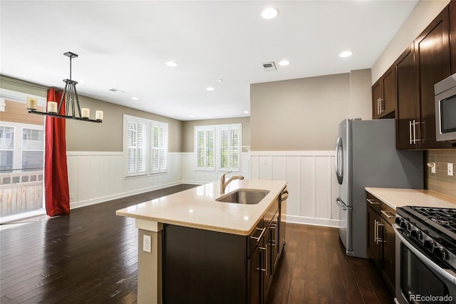 3450 Valentia St, Denver, CO 80238 - kitchen with a sink, a wainscoted wall, dark wood-type flooring, a kitchen island with sink, and dark brown cabinetry