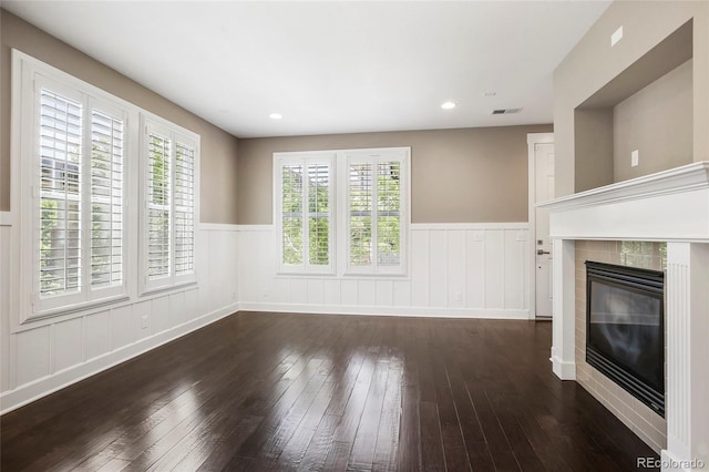 3450 Valentia St, Denver, CO 80238 - unfurnished living room with hardwood / wood-style flooring, a wainscoted wall, and a tile fireplace