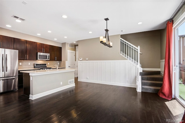 3450 Valentia St, Denver, CO 80238 - kitchen with stainless steel appliances, light countertops, dark wood-style floors, backsplash, and decorative light fixtures
