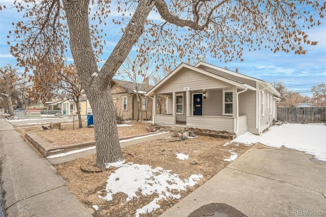 bungalow-style home with a porch and fence