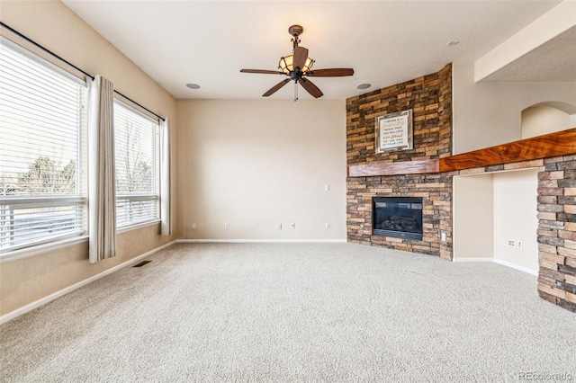 unfurnished living room with visible vents, a large fireplace, baseboards, carpet floors, and a ceiling fan