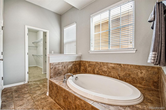 full bath with a bath, tile patterned floors, a spacious closet, and baseboards