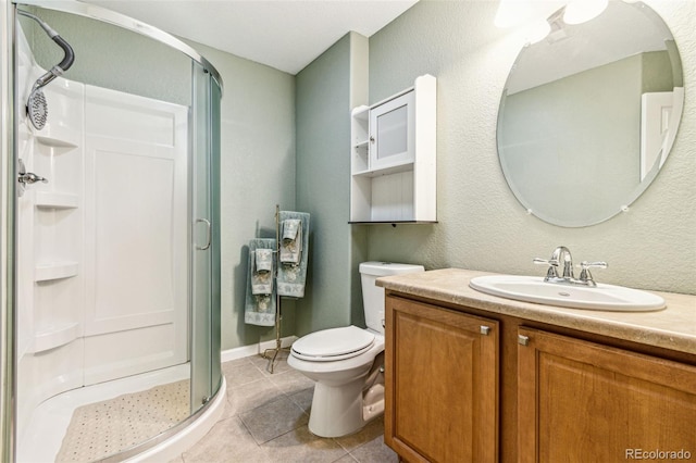 full bathroom featuring vanity, baseboards, a stall shower, tile patterned flooring, and toilet