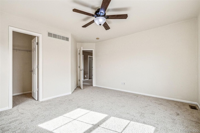 unfurnished bedroom featuring a spacious closet, visible vents, and carpet flooring