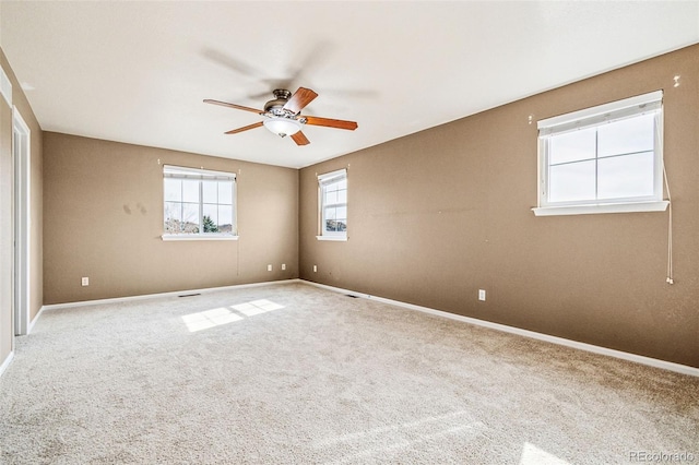 spare room with carpet flooring, baseboards, and ceiling fan