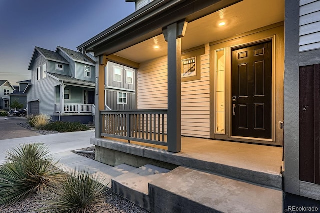 exterior entry at dusk featuring a porch