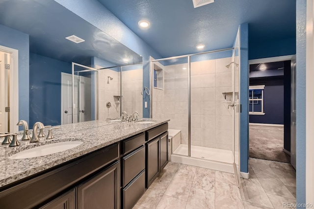 bathroom with vanity, a textured ceiling, and walk in shower