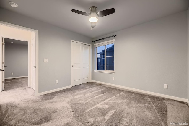 unfurnished bedroom featuring carpet floors, a closet, and ceiling fan