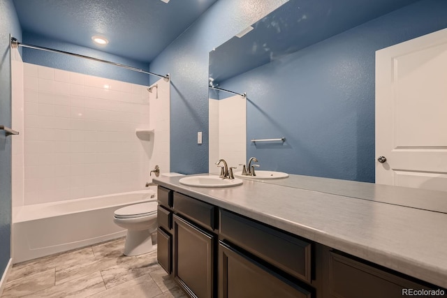 full bathroom with  shower combination, vanity, a textured ceiling, and toilet