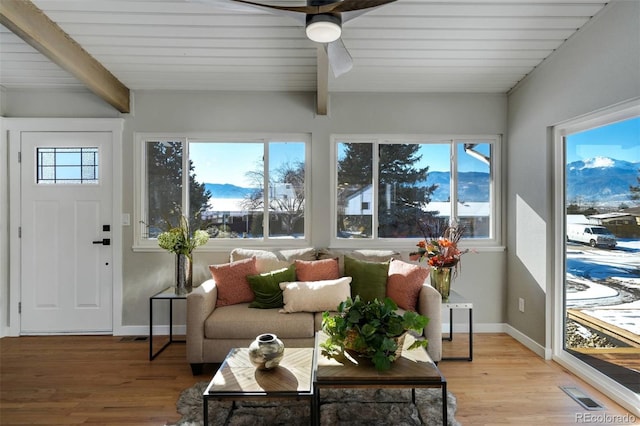 sunroom featuring ceiling fan, plenty of natural light, and beamed ceiling