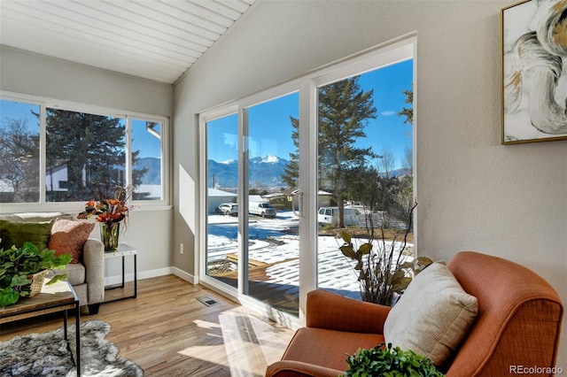 sunroom / solarium featuring lofted ceiling and a mountain view