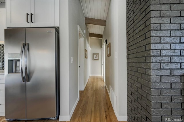 corridor featuring wooden ceiling, light hardwood / wood-style floors, and beamed ceiling