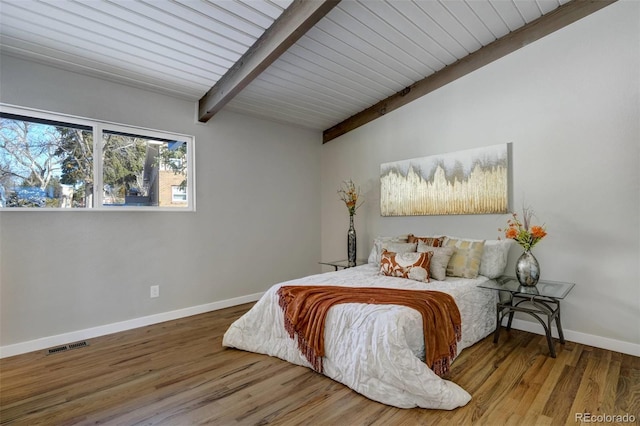 bedroom with vaulted ceiling with beams, wood ceiling, and hardwood / wood-style floors