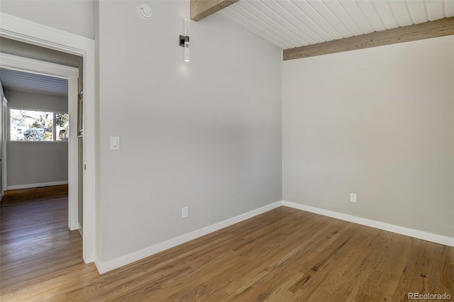 spare room featuring vaulted ceiling with beams, wood-type flooring, and wooden ceiling