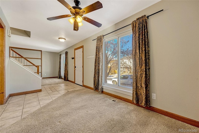 entrance foyer with ceiling fan and light colored carpet